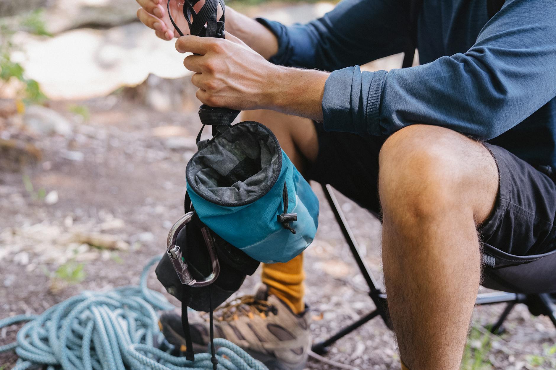 Turysta pakuje sprzęt wspinaczkowy z liną i woreczkiem na magnezję
