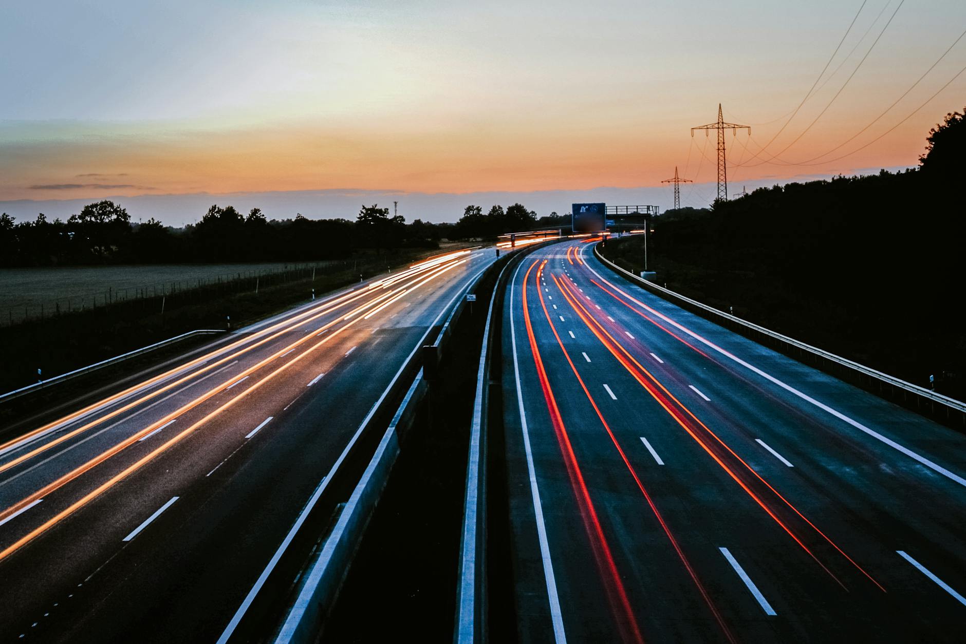 Świetliste smugi świateł samochodów na autostradzie A1 o zmierzchu