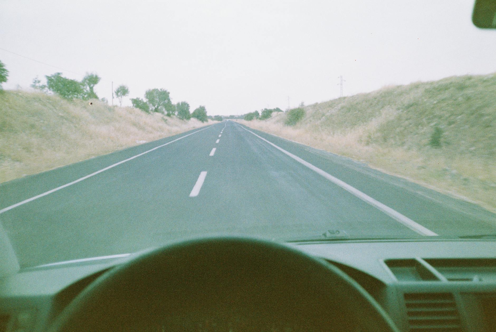 Pusta szosa prowadząca pośród wzgórz w kierunku horyzontu