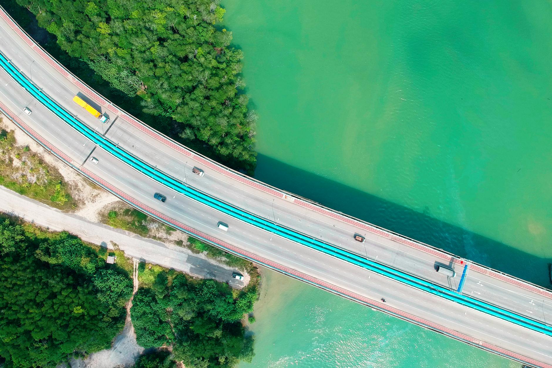 Autostrada na estakadzie nad turkusową wodą wśród zieleni