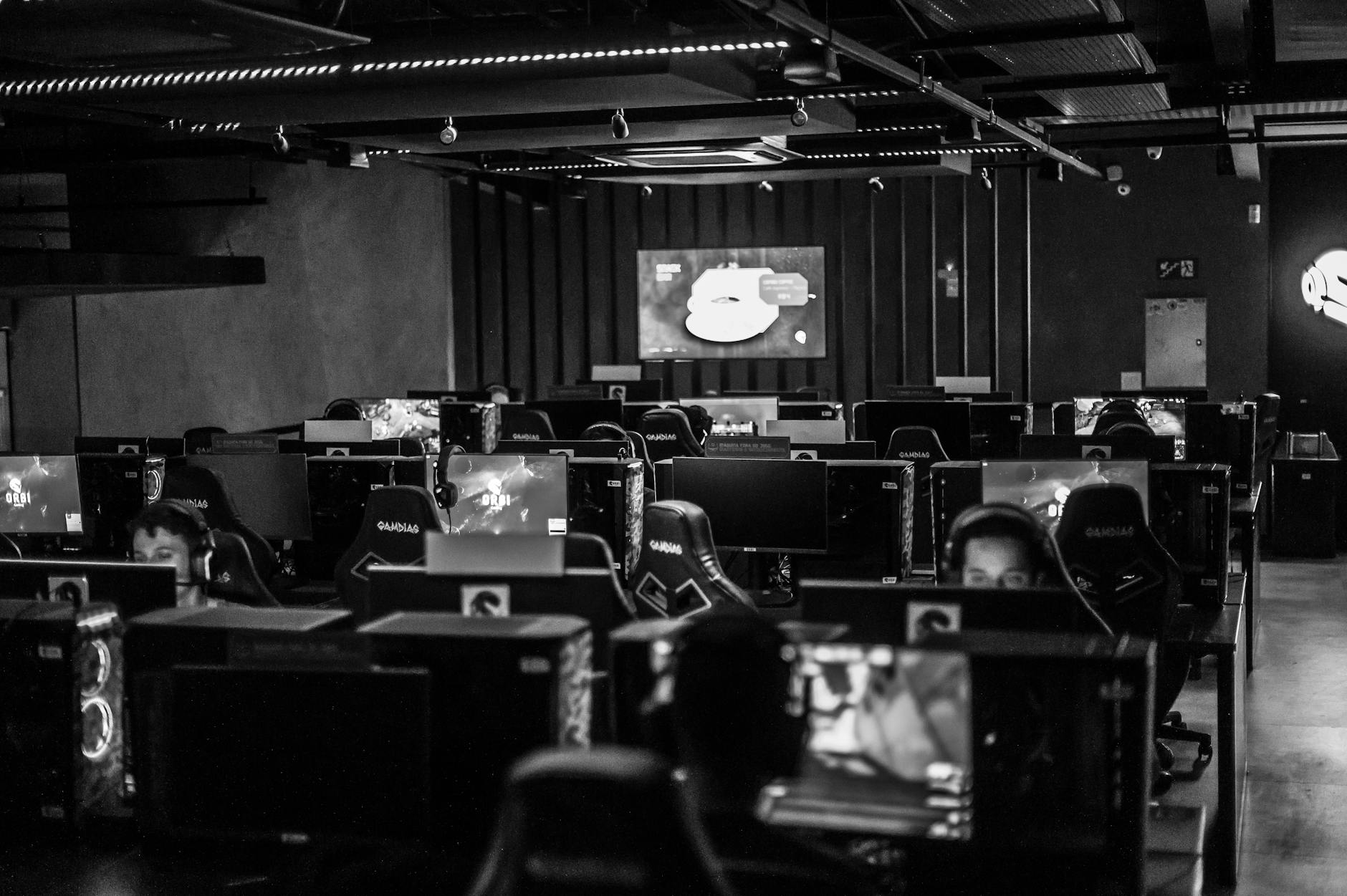 Gracze przy komputerach w studiu e-sportowym podczas rozgrywek