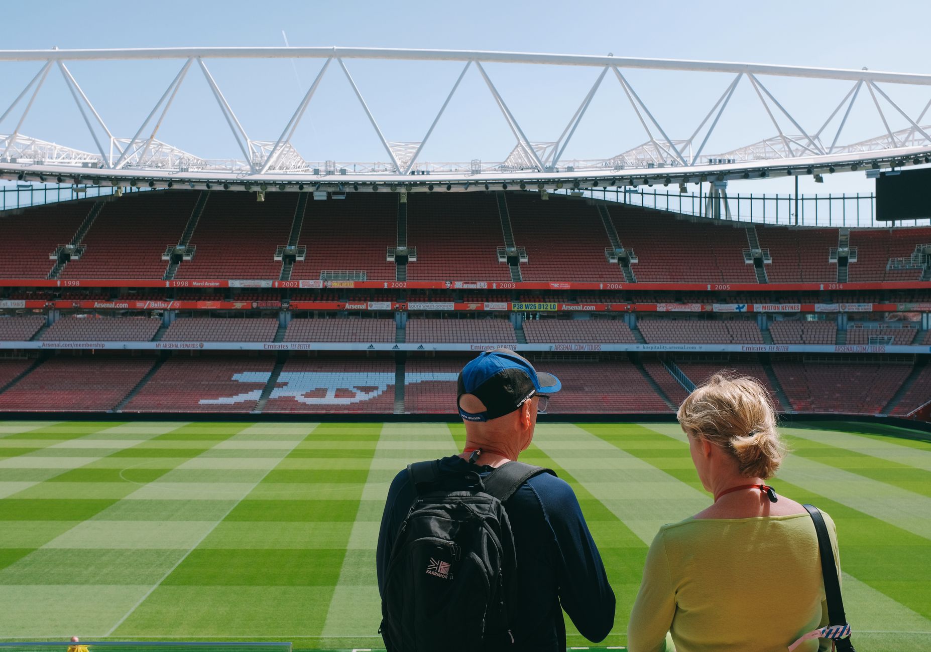 Turyści zwiedzający pusty stadion piłkarski z widokiem na murawę